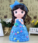 tirelire fille princesse en longue robe de mariage bleue avec un noeud papillon dans les cheveux et des petites fleurs.